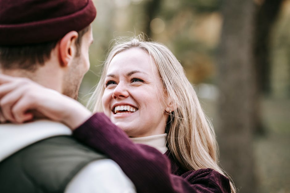 A joyful couple sharing an embrace in a scenic park setting, highlighting love and connection.