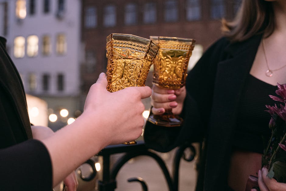 A couple enjoying an elegant toast with ornate glasses outdoors during the night.