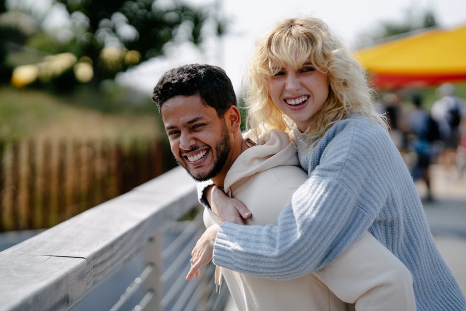 A joyful couple sharing a loving piggyback moment outdoors on a sunny day.