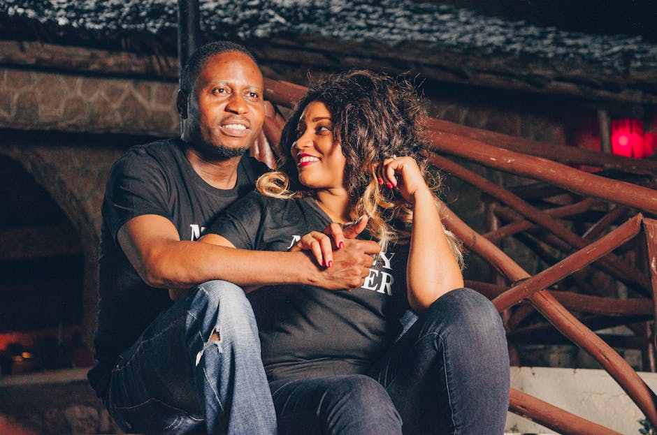 Joyful couple sitting together outdoors at night, capturing a romantic moment.