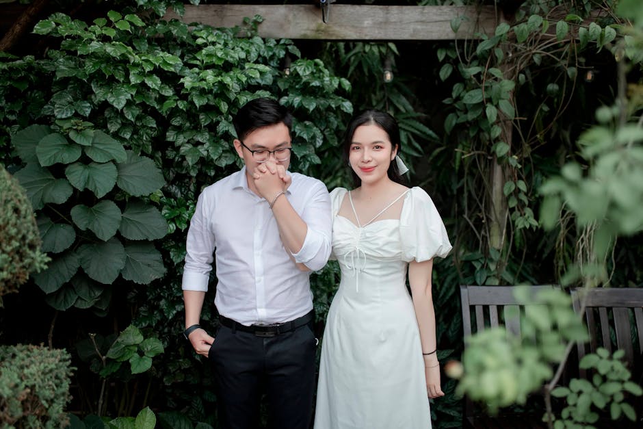 A happy couple enjoying a scenic outdoor setting surrounded by lush greenery.