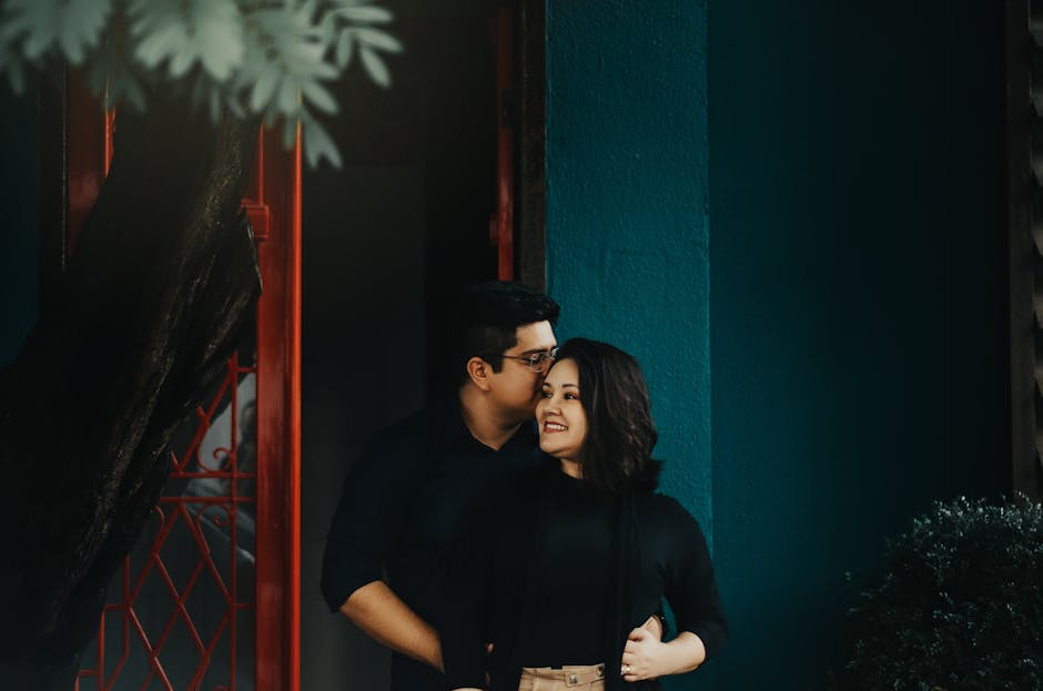 A romantic couple embracing under natural light with a warm, intimate atmosphere.