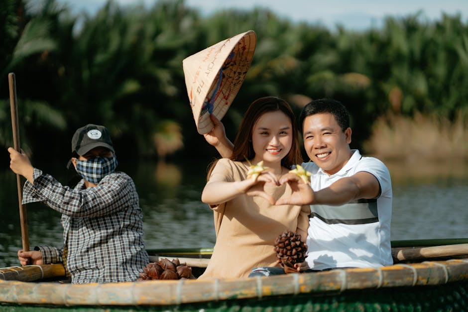 Asian couple making heart shapes with hands on a boat ride, embracing love and travel.