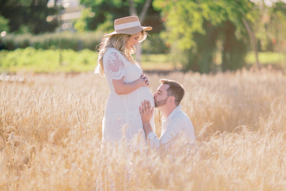 Expecting couple enjoying a sunny day in a wheat field, celebrating pregnancy and parenthood.