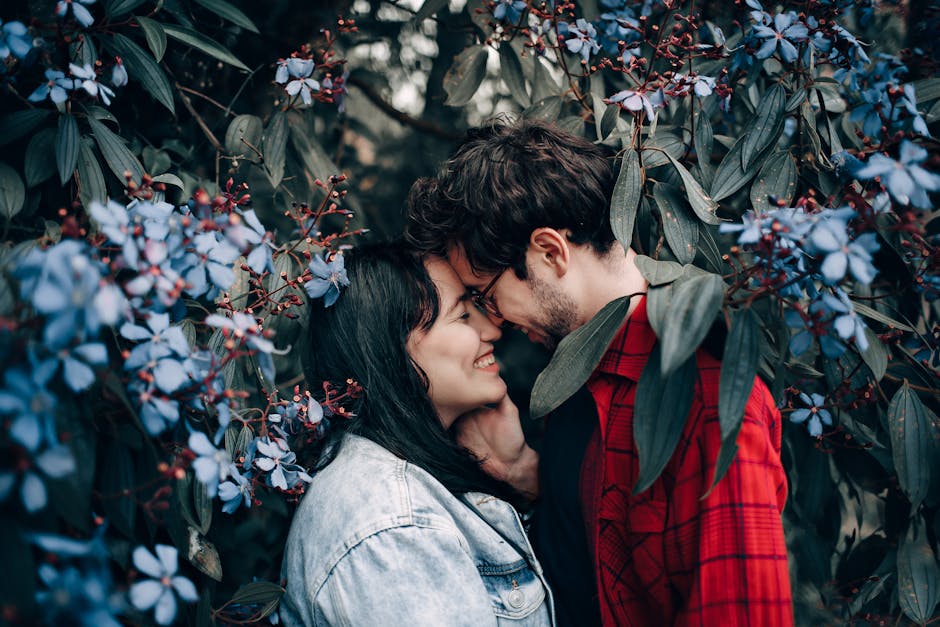Happy couple sharing a romantic moment surrounded by beautiful blue flowers.