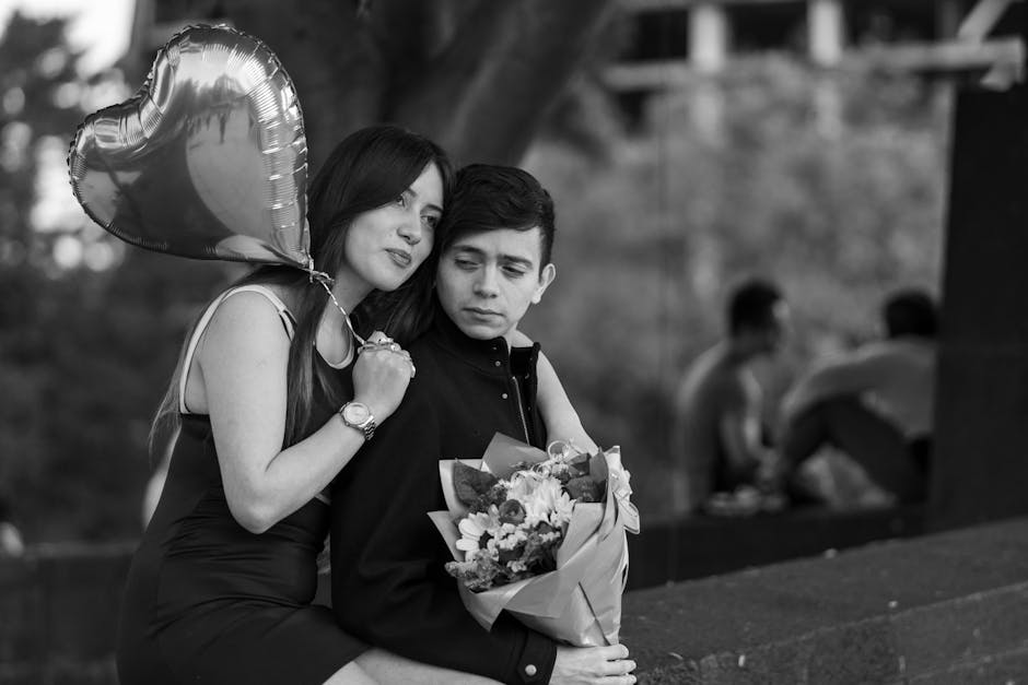 A couple sharing a romantic moment with a heart-shaped balloon and flowers.