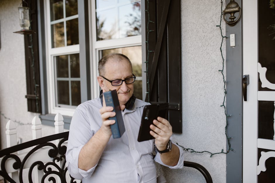 Senior man using a smartphone for video call while sitting on a cozy porch, smiling and enjoying the connection.