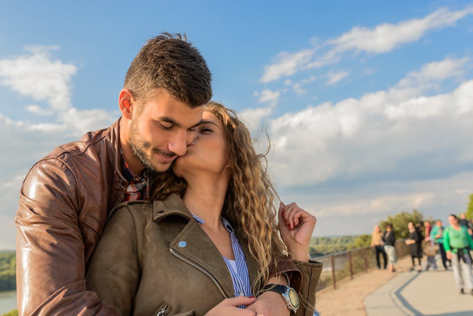 A loving couple embraces under a clear sky, showcasing romance and togetherness.