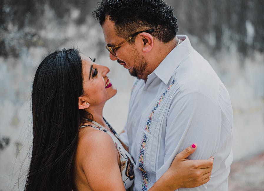 Closeup of a loving couple embracing with smiles, outdoor setting.