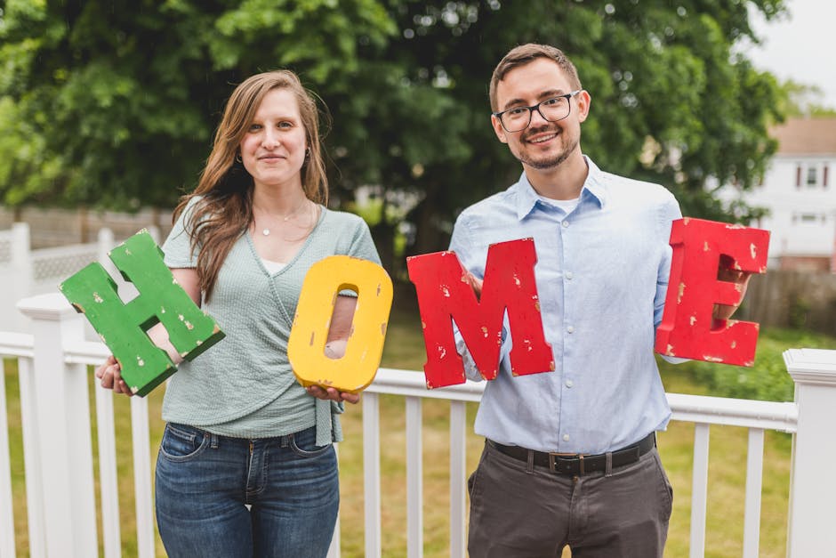 Couple holding colorful letters spelling 'HOME', symbolizing property investment and ownership.