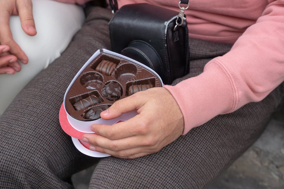 A couple sharing chocolates outdoors, emphasizing romance and connection.