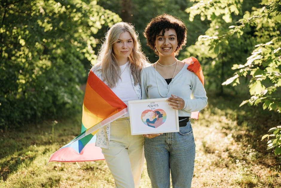 A loving couple embraces pride with a rainbow flag in a serene outdoor setting.