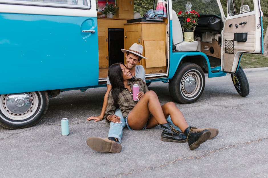 Happy couple enjoying a summer day by their retro campervan.
