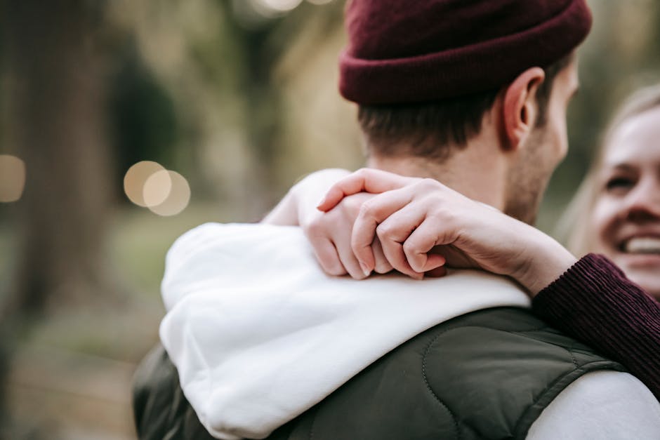 A joyful couple embraces in an outdoor setting, capturing a moment of romance and connection.