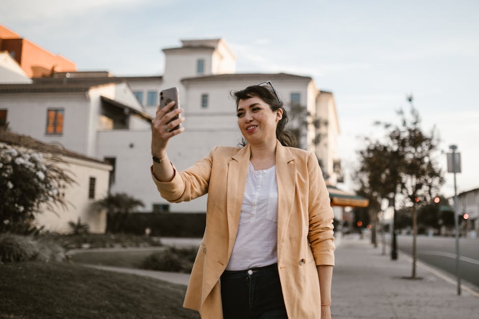 Smiling woman on a video call outdoors, showcasing modern urban lifestyle.