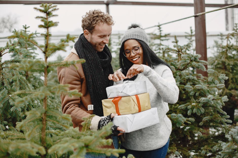 Happy couple exchanging Christmas gifts surrounded by fir trees, celebrating togetherness.