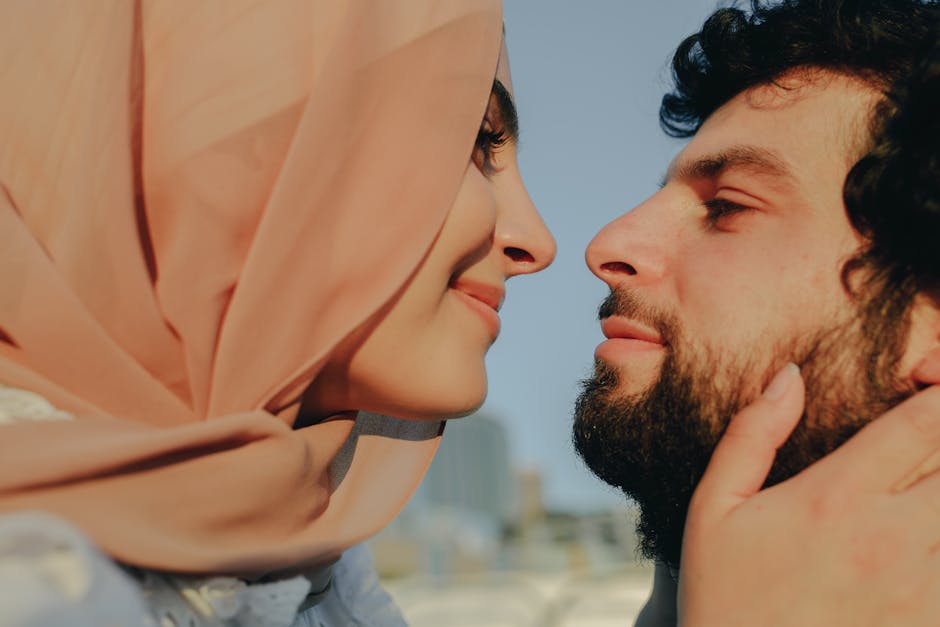 A close-up of a happy couple sharing a tender moment outdoors, with faces close together.