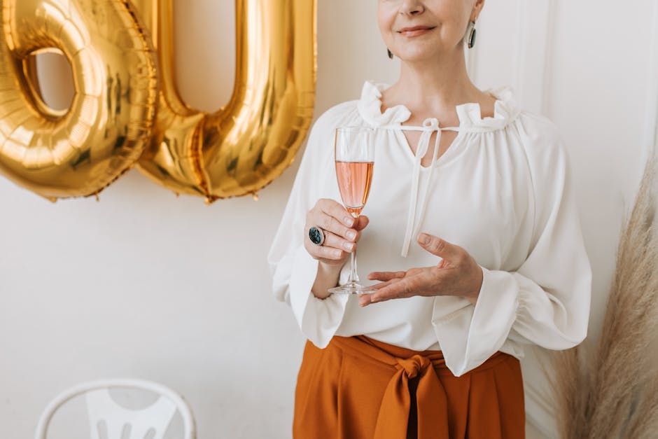 Senior woman celebrating her 60th birthday with elegance, holding a glass of champagne.