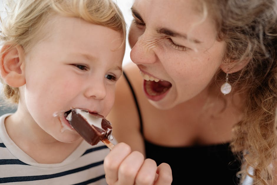 A playful moment captured between a mother and her son enjoying a chocolate ice cream.