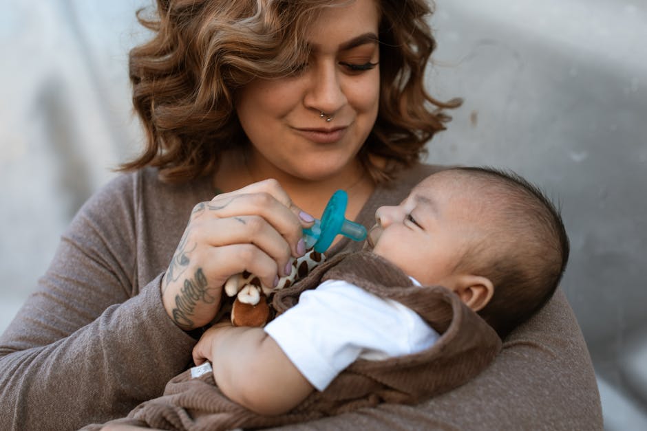 A mother lovingly holds her baby boy, showcasing tender affection and parenthood indoors.