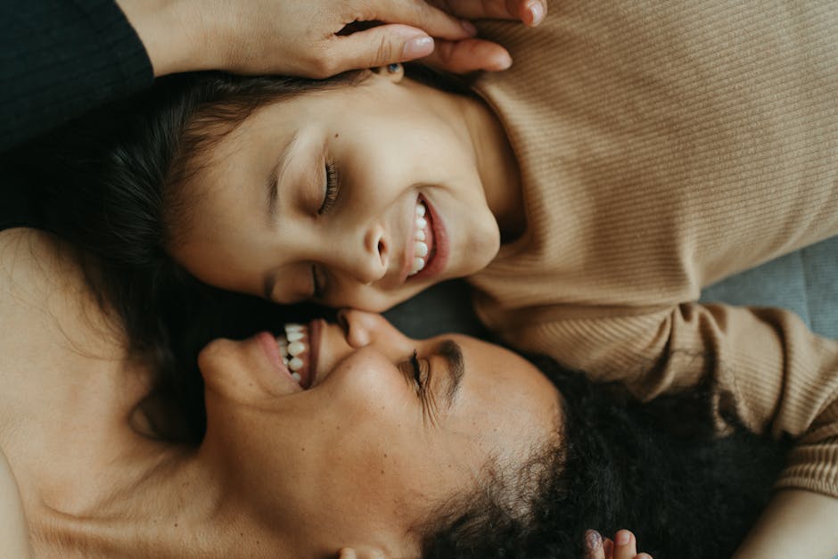 Close-up of a mother and daughter smiling joyfully, showcasing their playful bond and happiness.