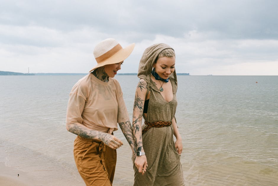 Two friends enjoy a sunny walk on the beach, embracing happiness and togetherness.