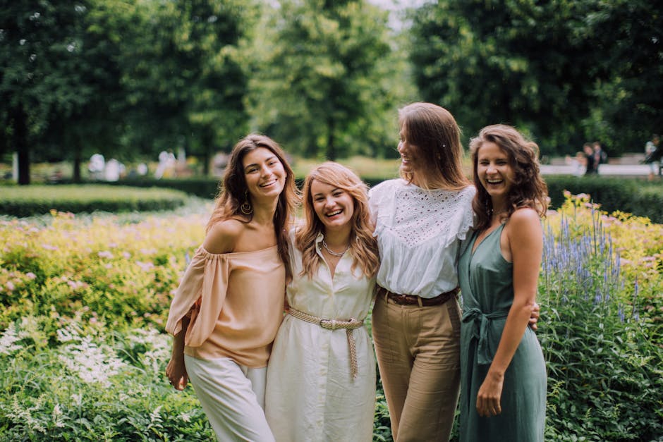 A joyful group of women standing together in a sunny park, symbolizing friendship and togetherness.