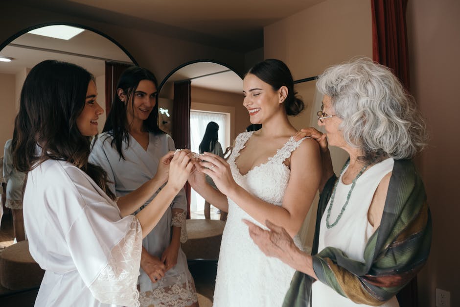 Bride shares a joyful moment with bridesmaids and elder woman, capturing wedding day happiness.