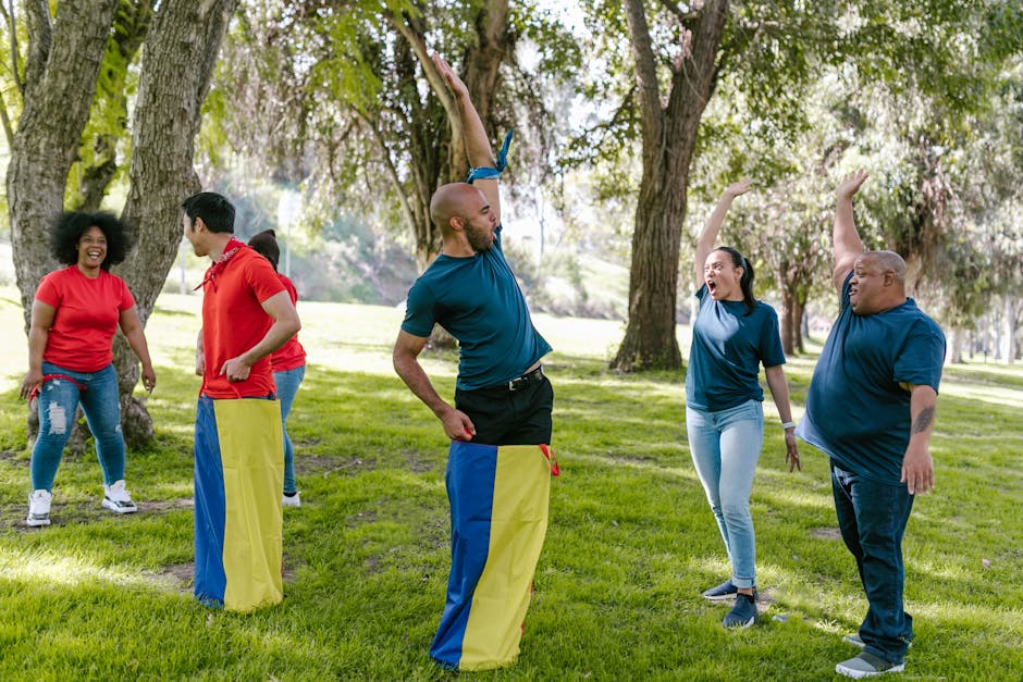 Group of adults enjoying team building games with cheer in a green park.