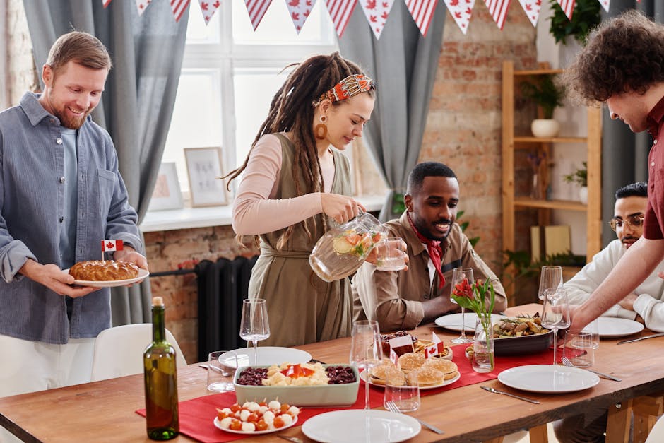 A diverse group of friends enjoy a festive Canada Day meal indoors with flags and food.