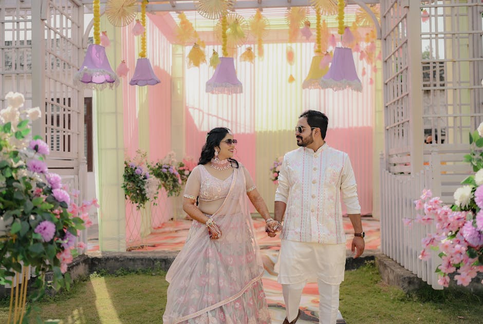 A couple in colorful traditional attire at a beautifully decorated outdoor wedding venue.