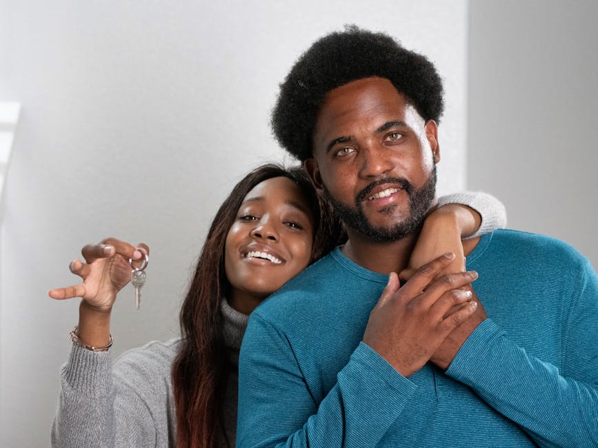 Joyful couple celebrating new home ownership with keys in hand.