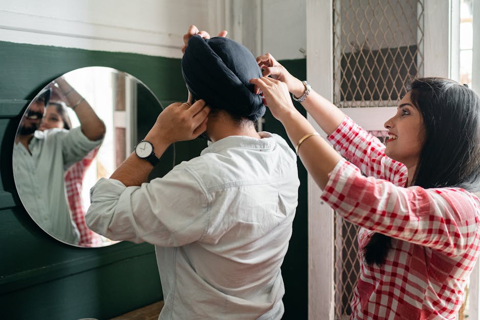 A happy couple sharing a loving morning routine indoors, adjusting a turban.