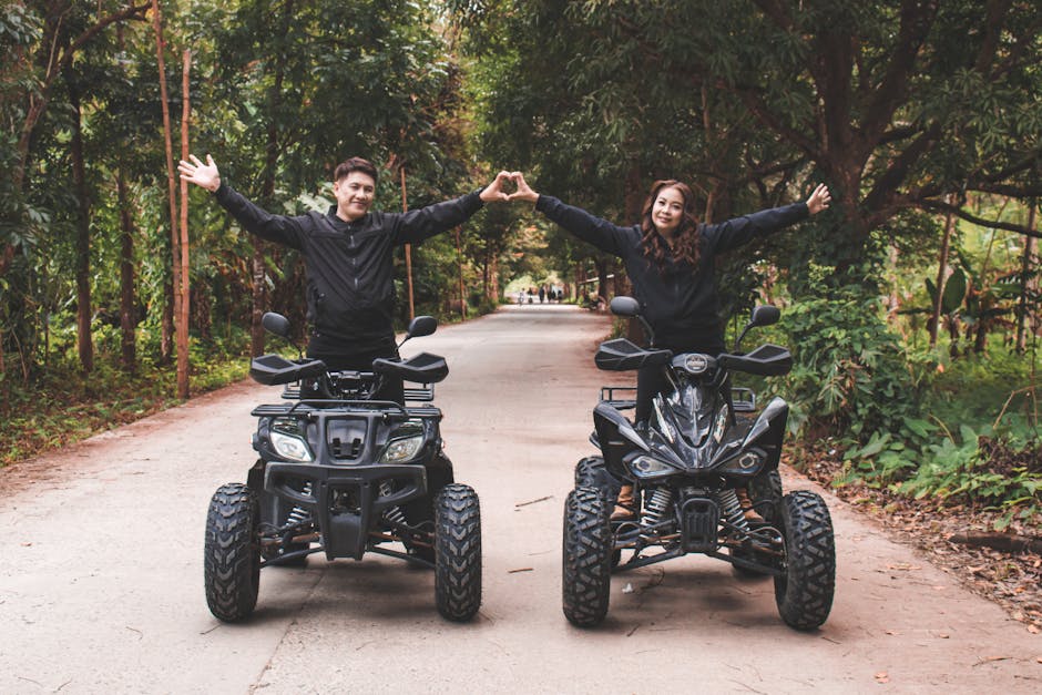 A joyful couple riding quad bikes on a forest road, expressing love and adventure.