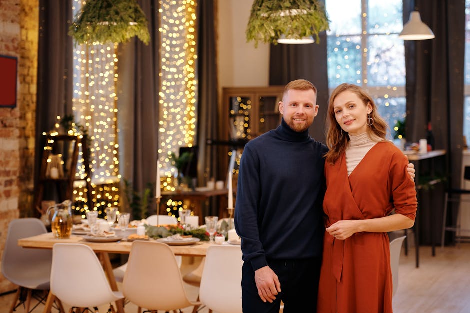 A happy couple celebrating Christmas indoors by a decorated dining table.