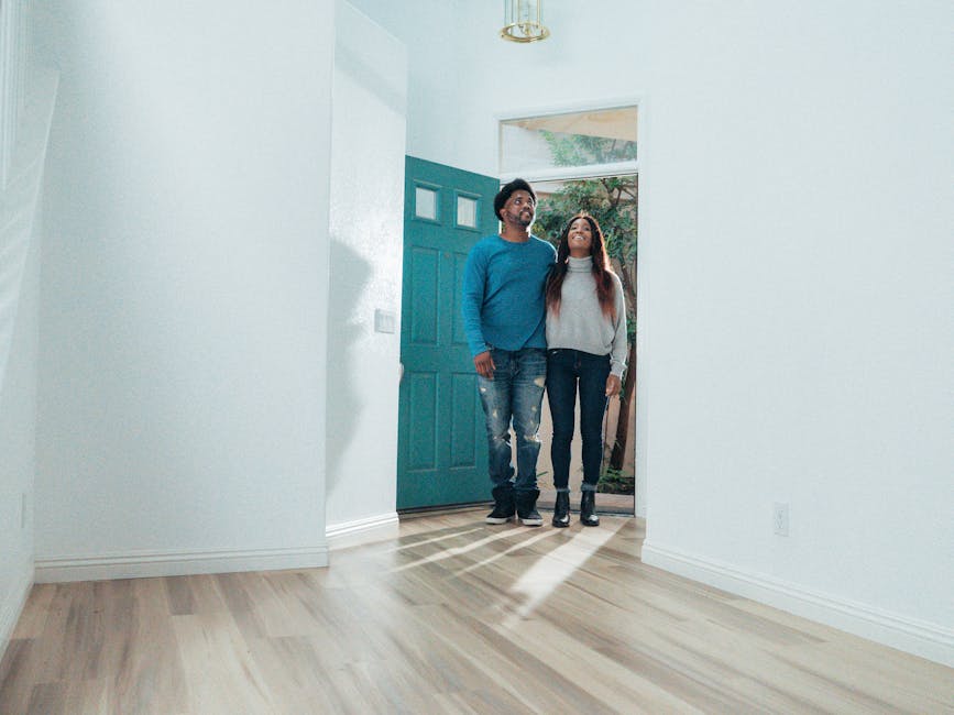 A cheerful couple stands in their new home, experiencing the excitement of ownership.
