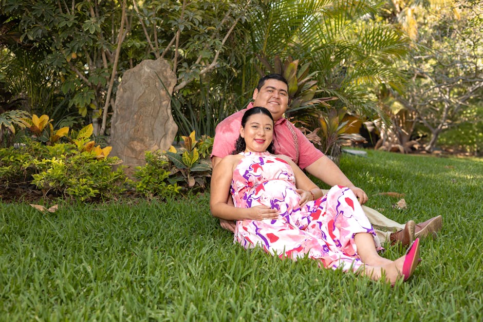 Happy pregnant couple sitting together in a lush garden in Dzununcán, Yuc., México.