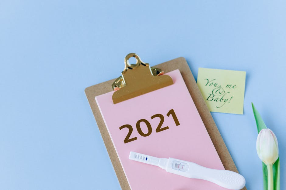 A positive pregnancy test on a clipboard marked 2021, with a note saying 'You, me & Baby!' and a tulip, symbolizing new life.