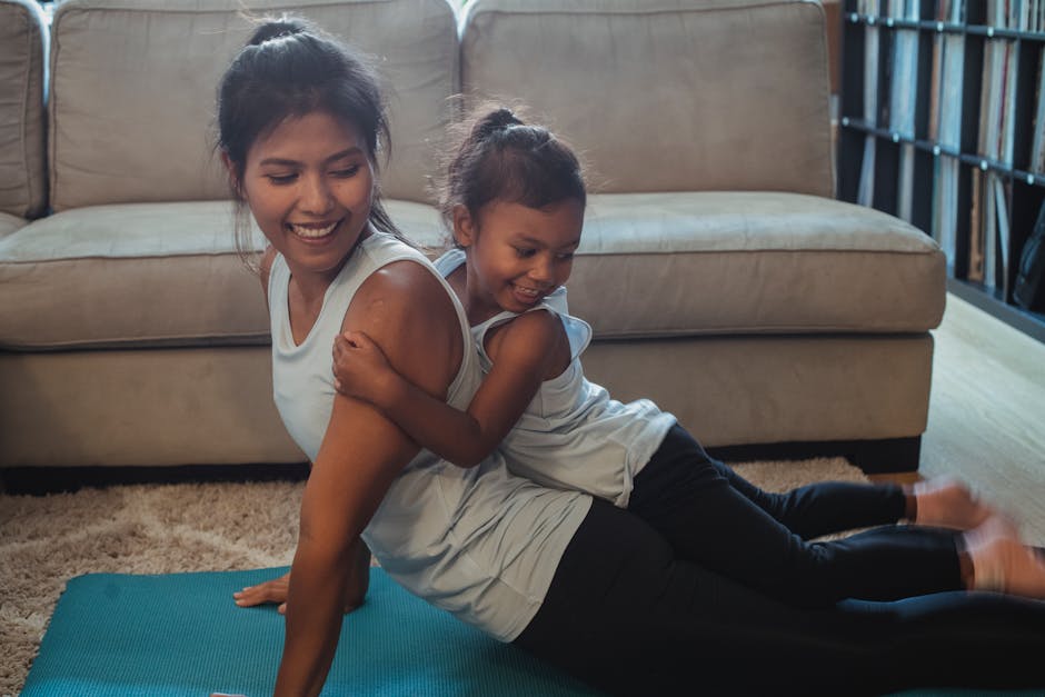 A mother and her young daughter share a joyful moment doing yoga at home.