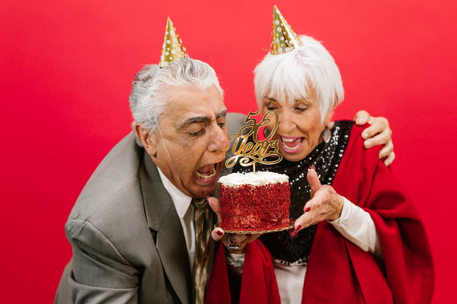 Cheerful elderly couple celebrating their 50th anniversary with a festive cake and joy.