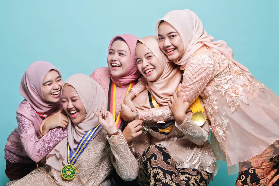 Joyful group of young women in hijabs celebrating graduation together.