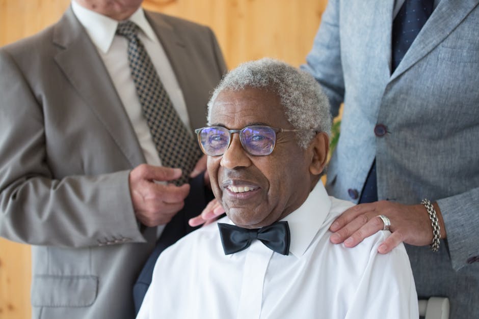 Joyful elderly man with bowtie at a wedding in Portugal, surrounded by guests.