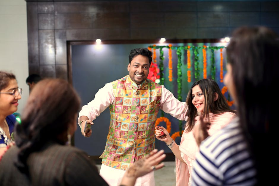 A groom and friends celebrating a joyful traditional Indian wedding indoors.