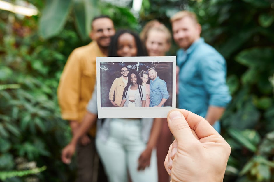 A group of friends enjoying a moment with an instant camera photo surrounded by lush greenery.