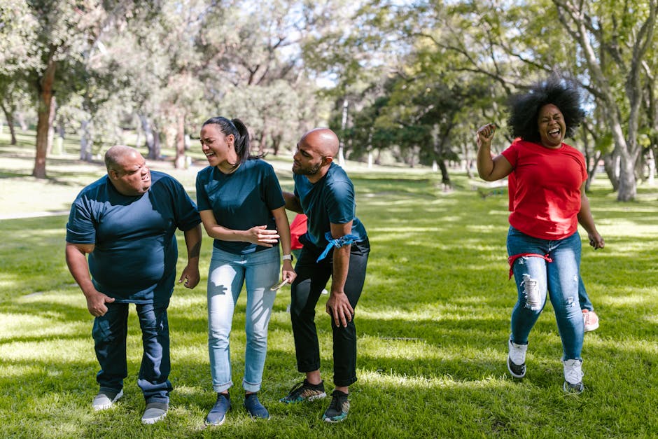 A joyful group of adults participating in a fun outdoor team-building exercise.