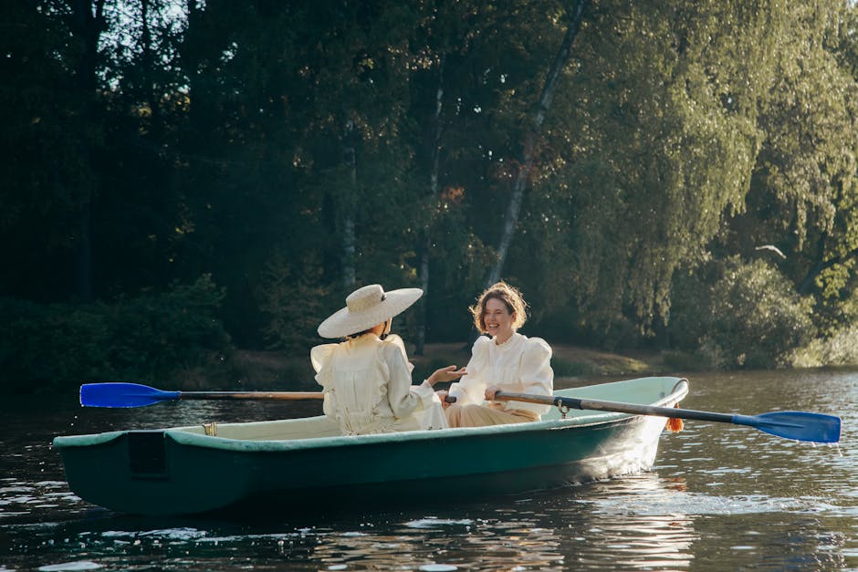 Two women in vintage dresses rowing a boat on a peaceful forest lake, enjoying the summer day.