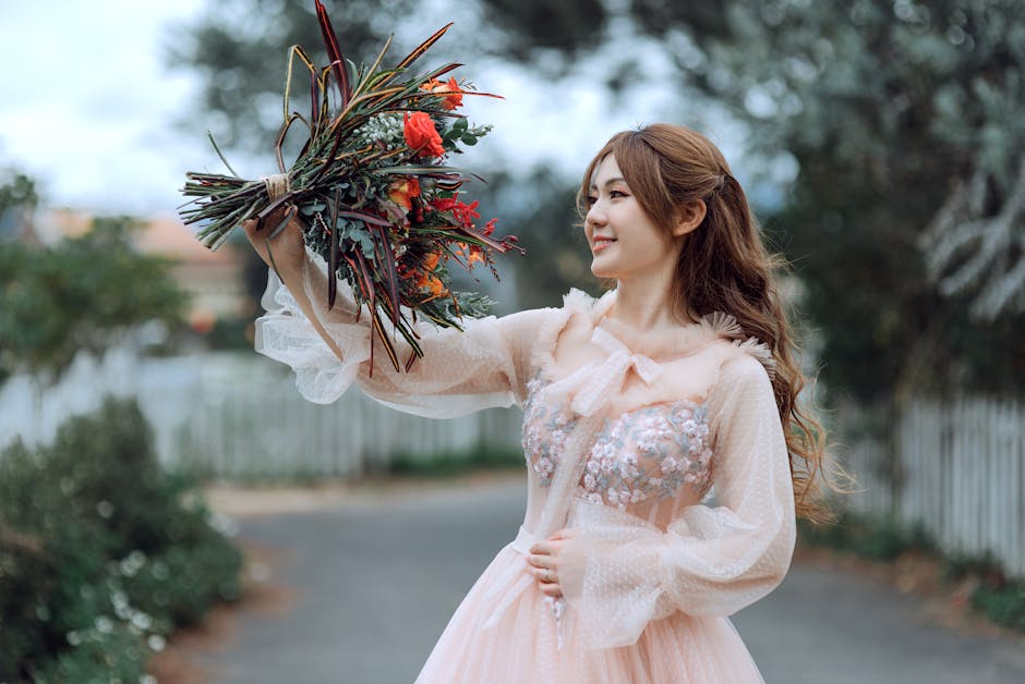 A beautiful woman in a delicate dress holds a vibrant floral bouquet outdoors, expressing joy.