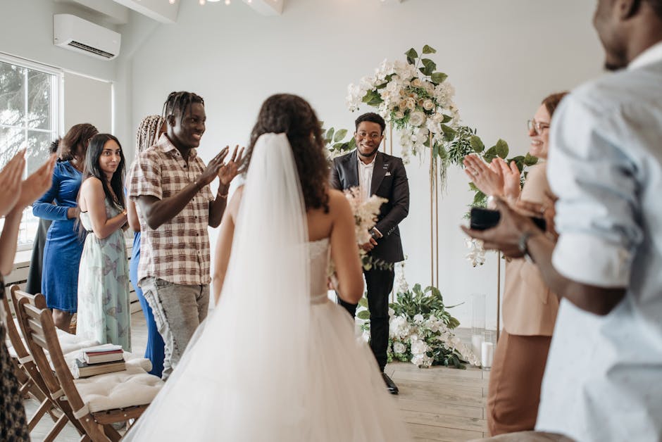 Bride walking towards the groom in a lively indoor wedding setting with diverse guests celebrating.