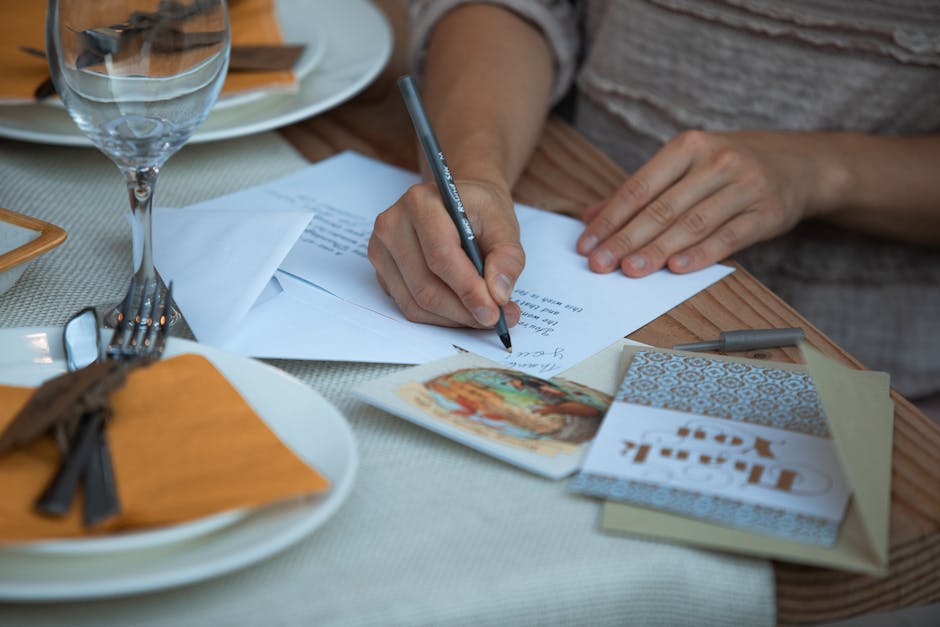 Woman writing thank you notes at a Thanksgiving dinner table setting.