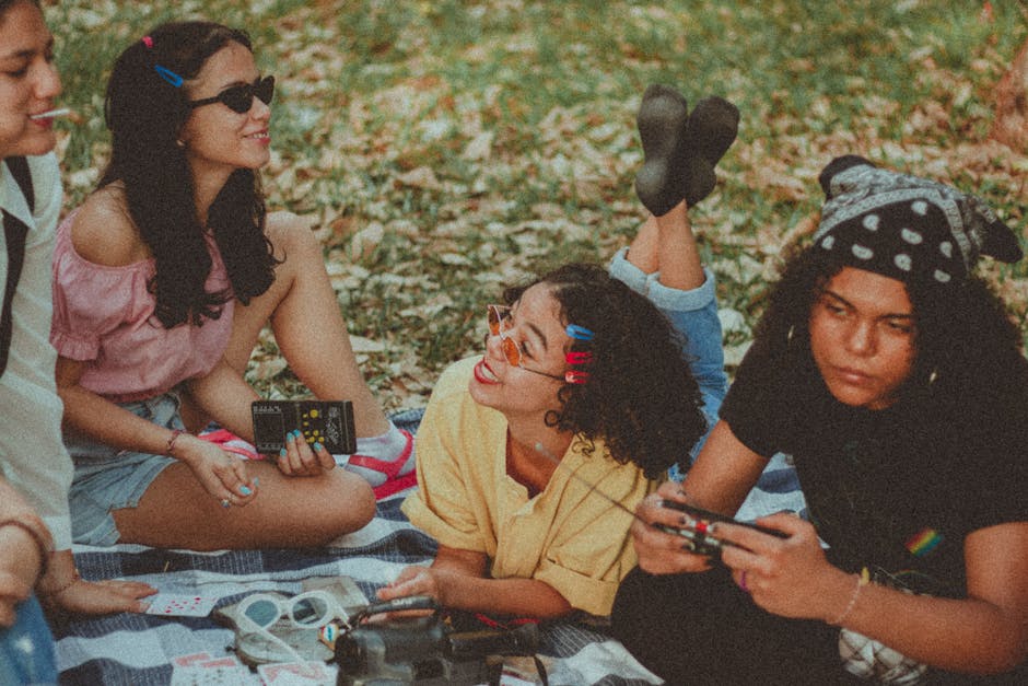 Group of friends enjoying a fun picnic with games and music on a fall day.